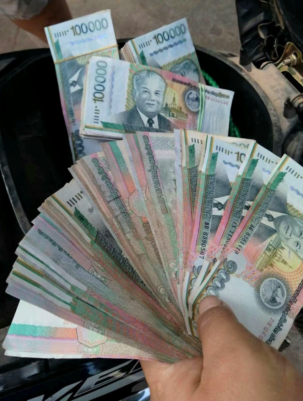 老挝币最大面值10万,换成人民币是42块,加满一箱油得100多万,一家人