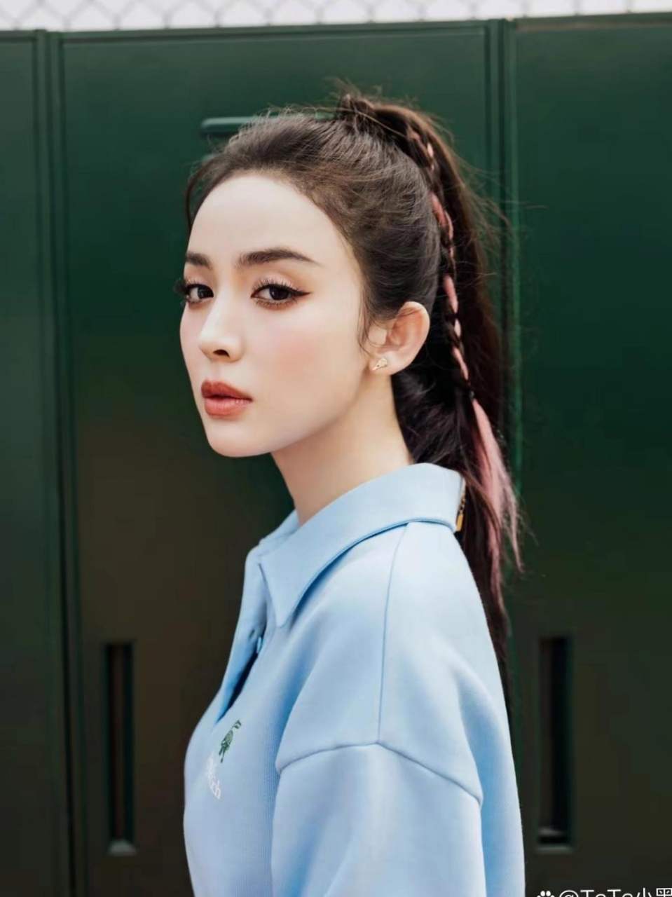 穿蓝色运动套装的古力娜扎梳着染色粉的高马尾,拿着羽毛球拍,青春活力