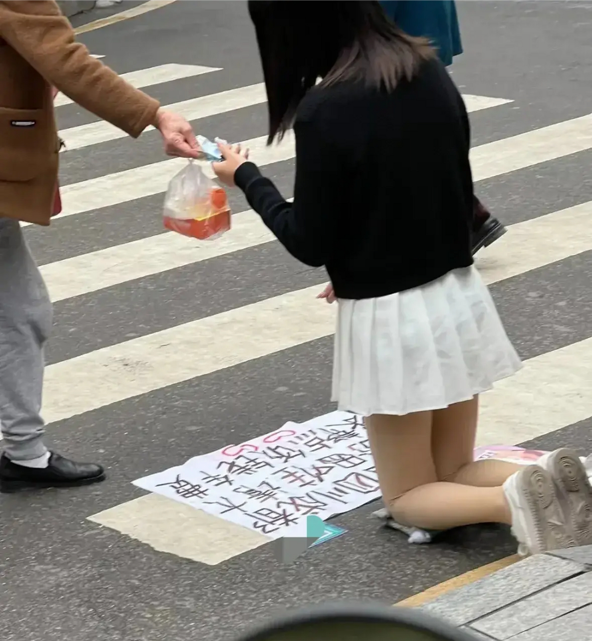 最近,重庆街头一位身穿白色长裙的女孩子跪在隧