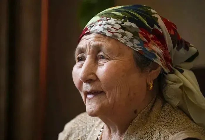 1977 年的冬天,新疆一名头戴破旧帽子的 11 岁汉族小姑娘,正在垃圾桶