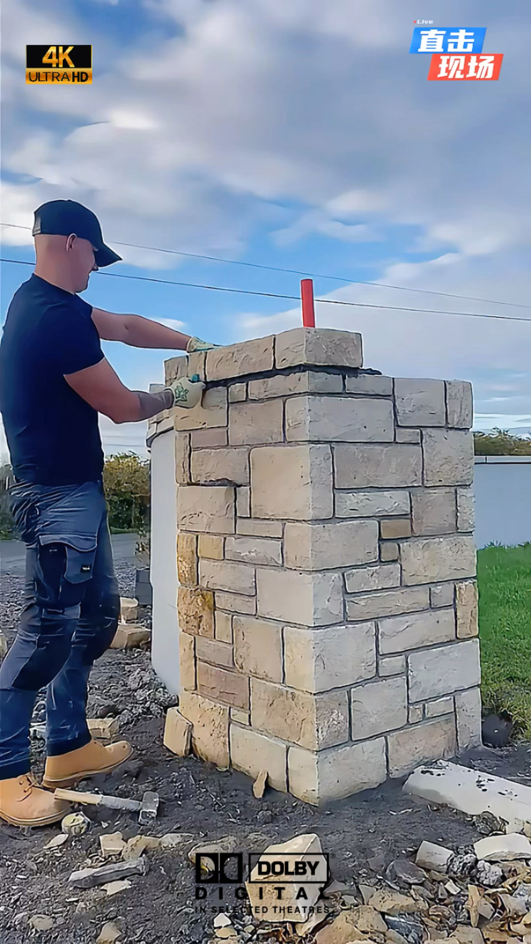 别墅庭院装修改造中,师傅正在用石块垒大门柱子