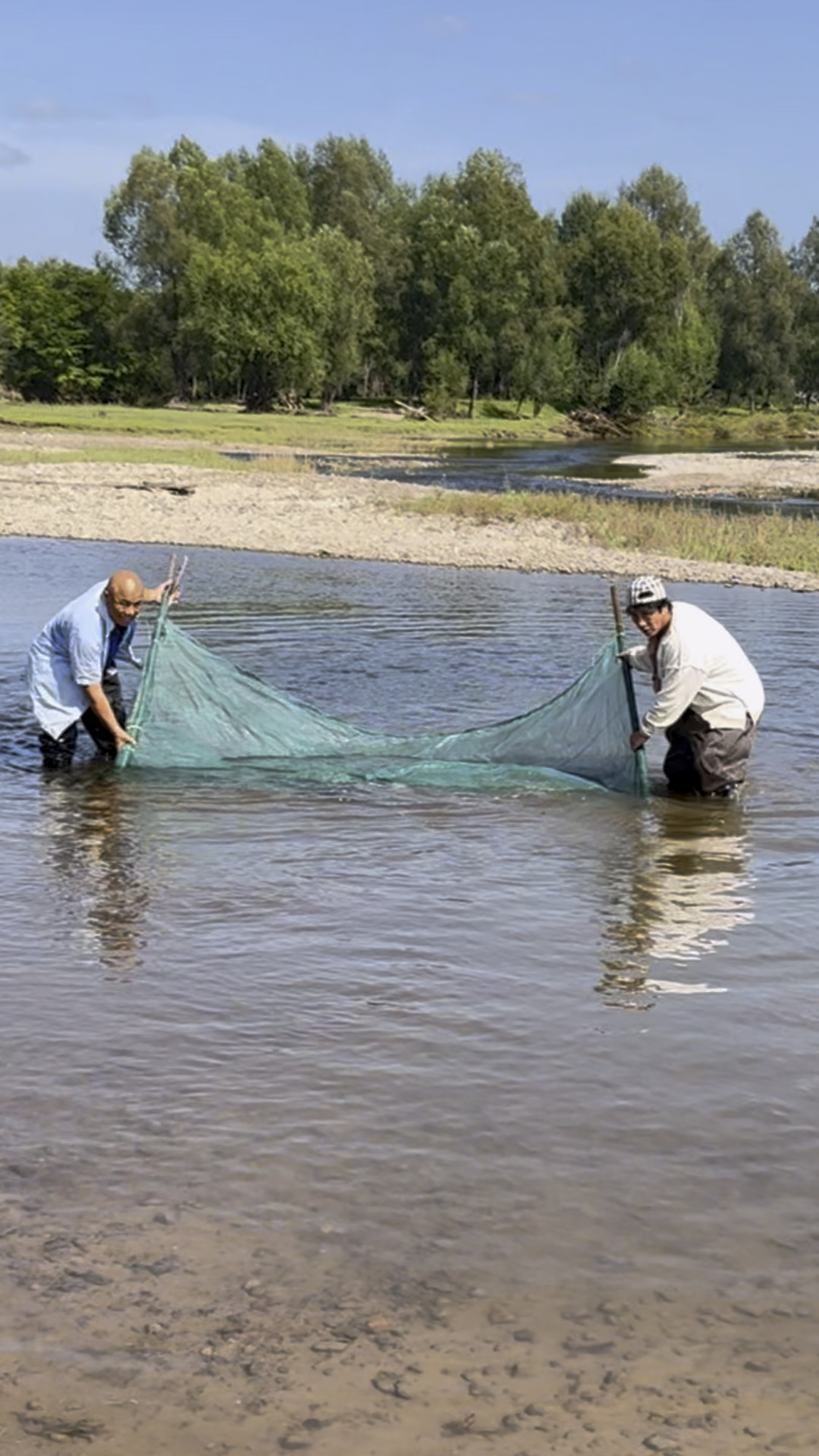 两个人一起用大拉网抓鱼看收获