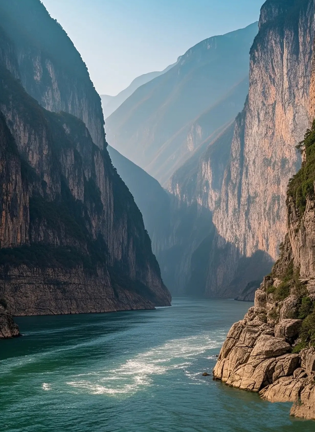 两岸奇峰罗列,悬崖峭壁如刀削斧砍.江水奔腾咆哮,浪花飞溅,气势磅礴