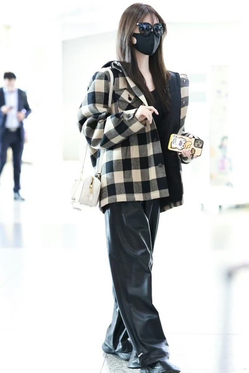 女明星# 祝绪丹机场照,她穿了一件黑白棋盘格子的连帽毛呢短外套,内
