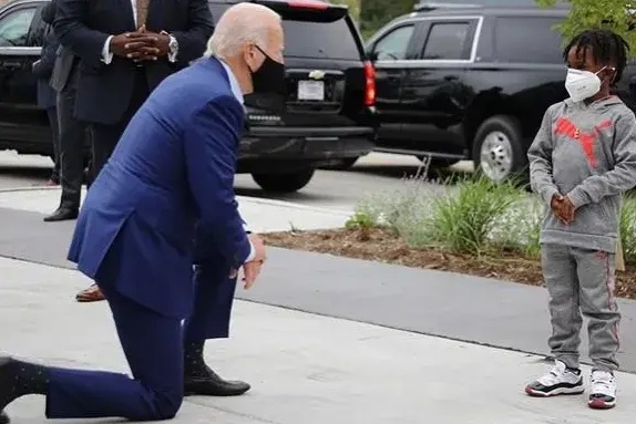 拜登好有爱心,居然单膝向一位黑人小男孩下跪,拜登对小男孩说:"我不是