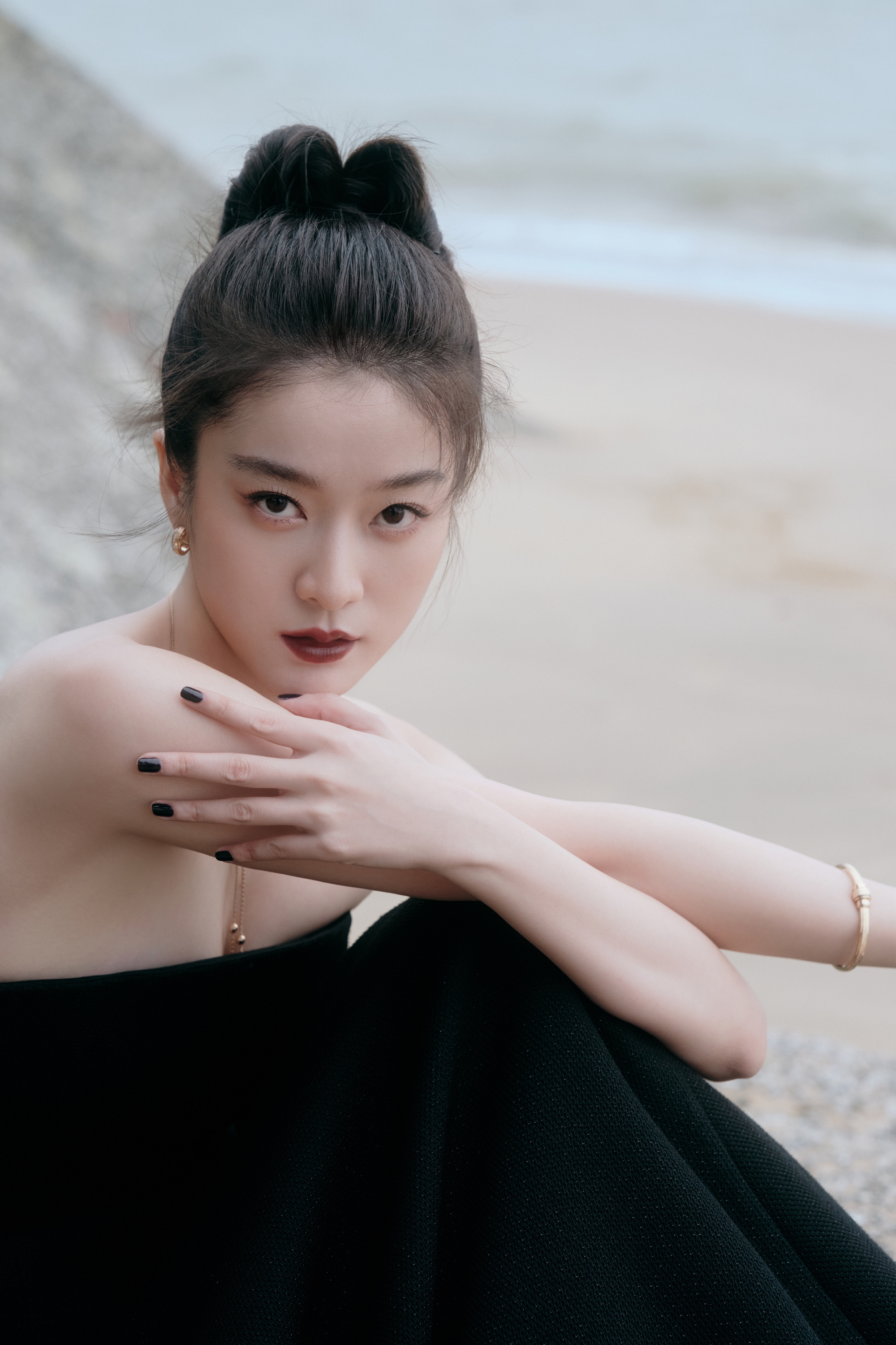 张雪迎沙滩大片:黑色抹胸礼服尽显优雅,海天一色中绽放自然美