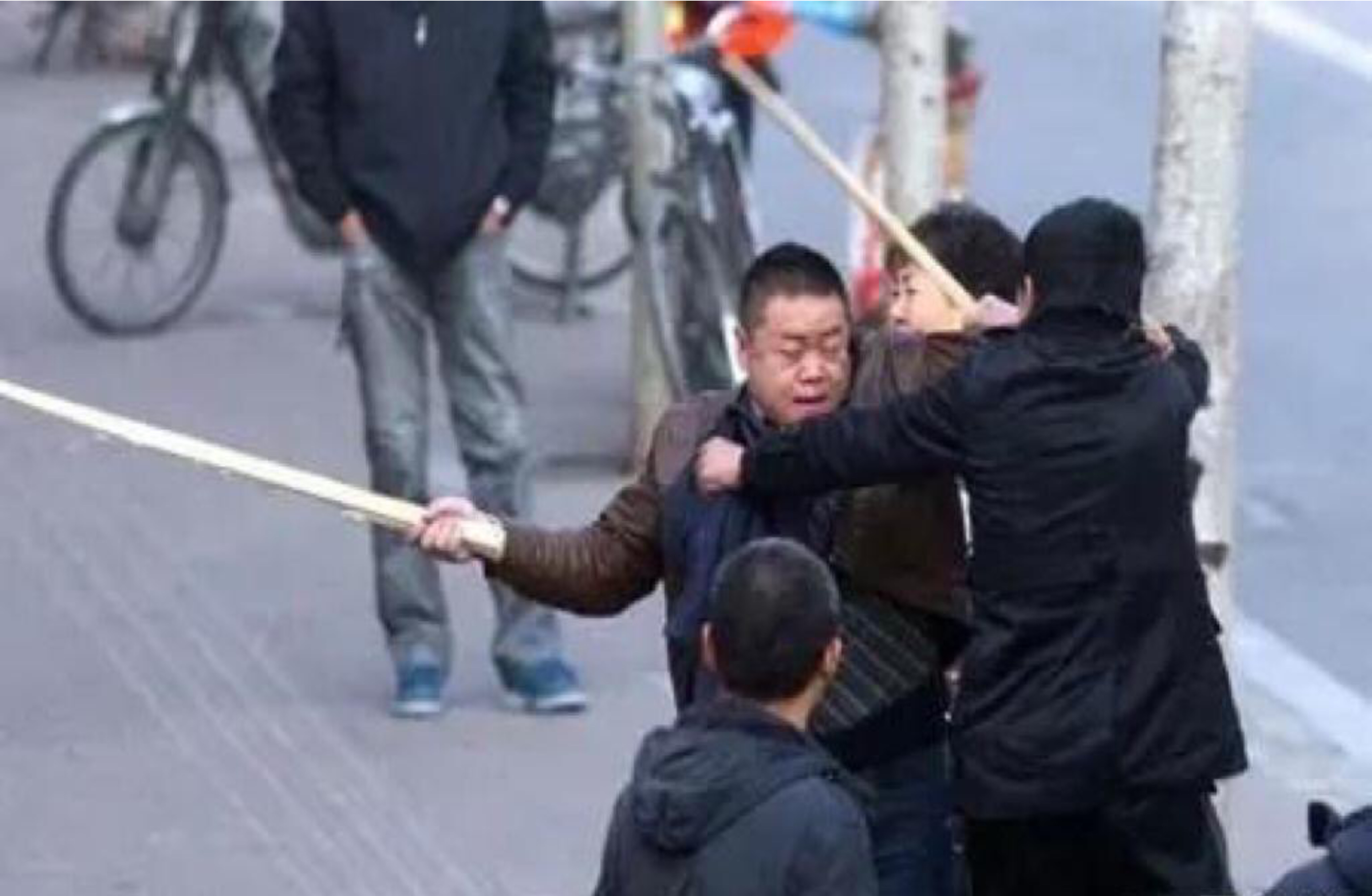 在一小区门口,两名男子正扭打在一起,激烈的争吵声