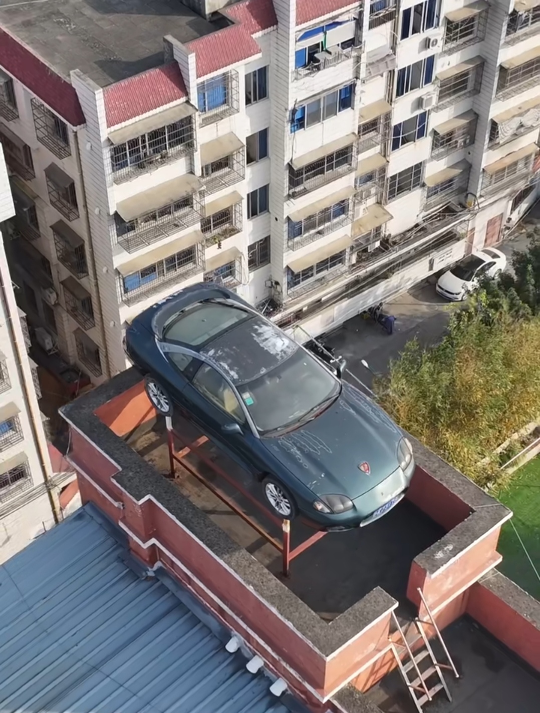 浙江温州一位牛人把自己的爱车放在了自家楼顶上,而且一放就是20多年