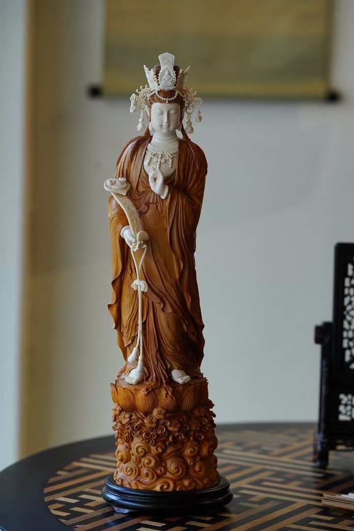 观音开脸饱满,神情静谧慈悲,宝衣雕刻凝练舒朗,手持如意,线条秀劲