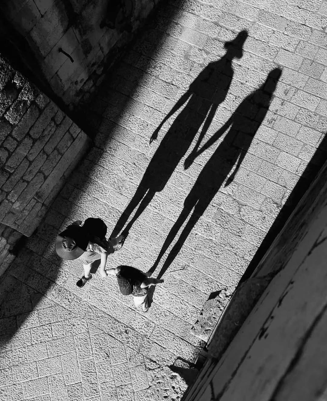 构图上,摄影师大胆采用俯视角度,将人物与影子巧