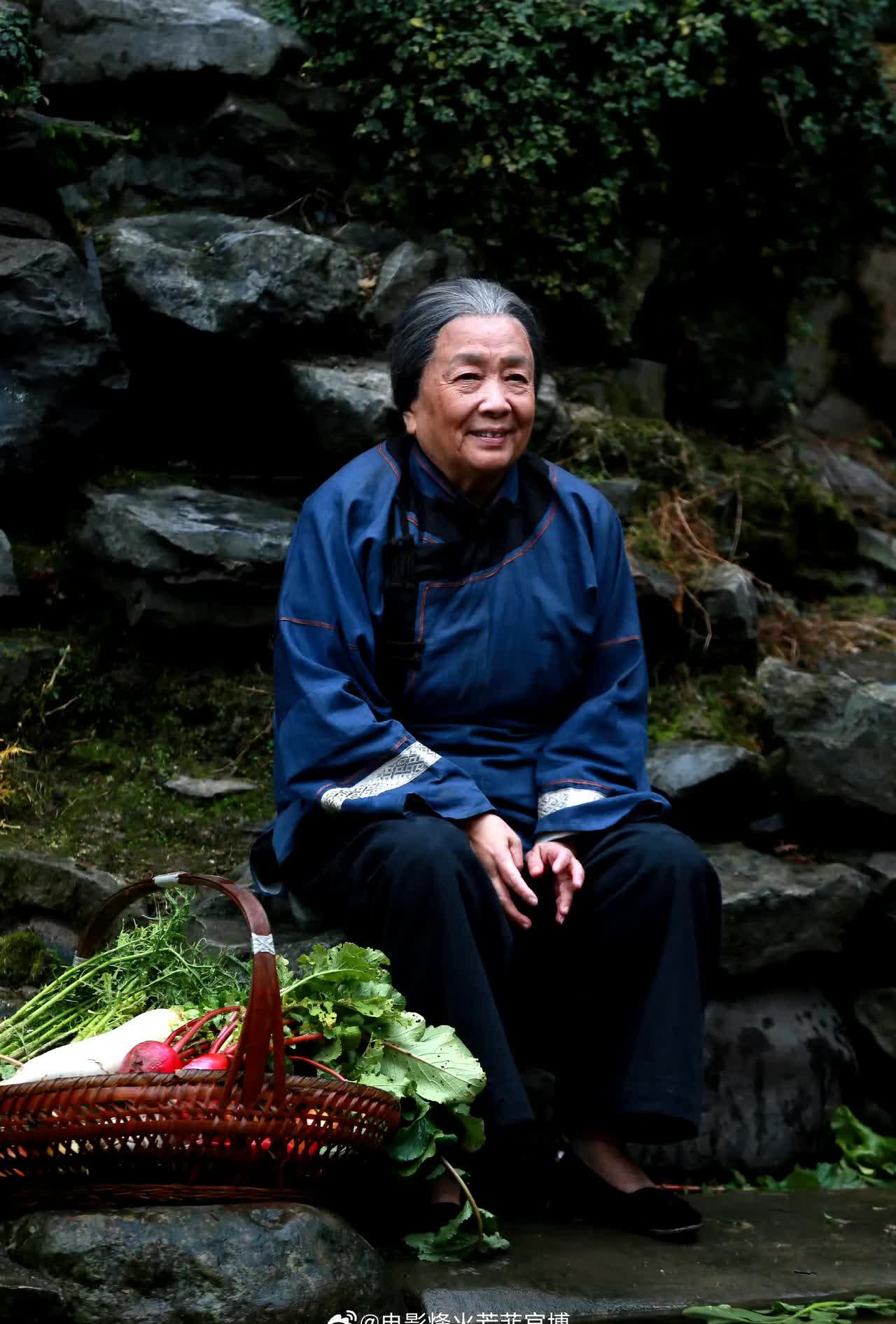 艺术家谢芳和刘亦菲拍电影花絮照,两人都穿着蓝色盘扣