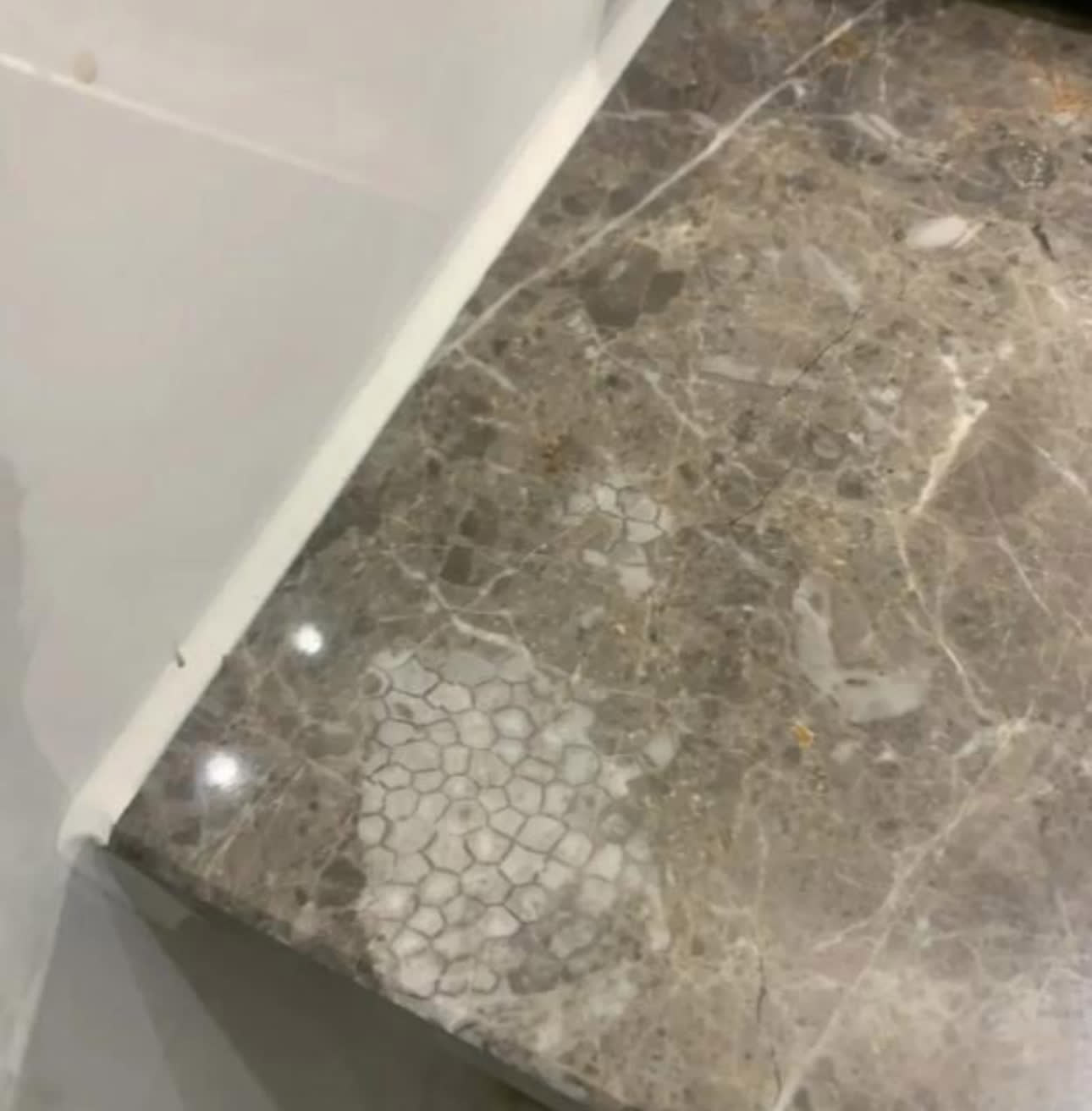 方便完后洗手的时候男子偶然看到洗手台的大理石上有一片不太一
