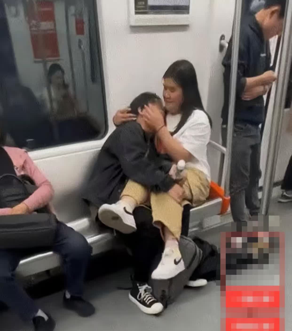 地铁车厢内,一对男女无视环境紧密相拥,女子坐男子腿上,举止刺眼