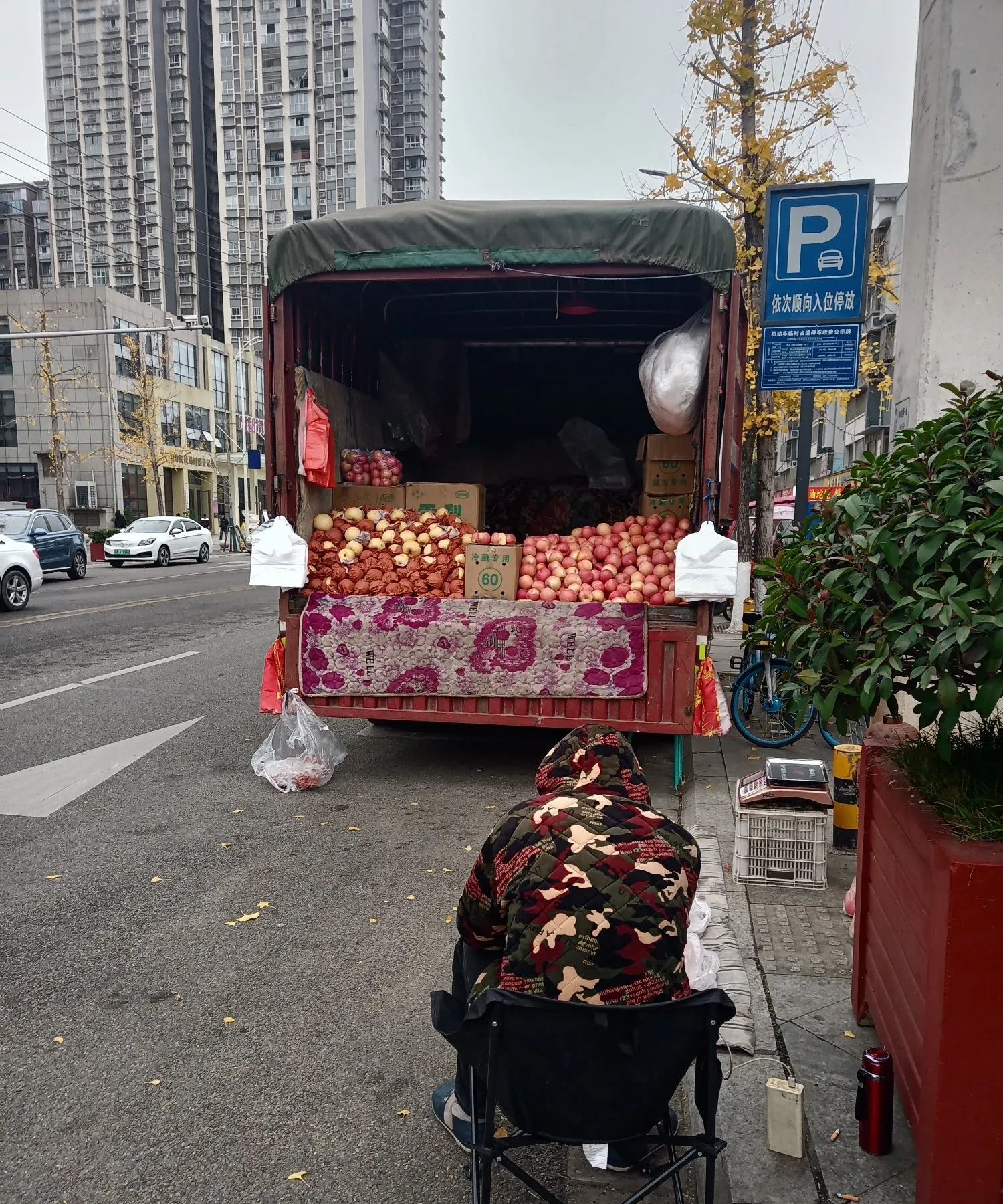 这辆卖苹果的车已经在这条街上停了快一个月了,每次经过都能看见这位