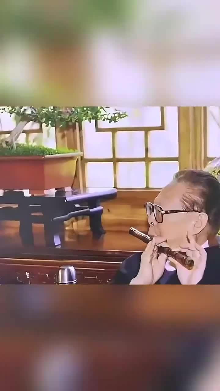 江同志退休后,在扬州老家吹笛子的画面