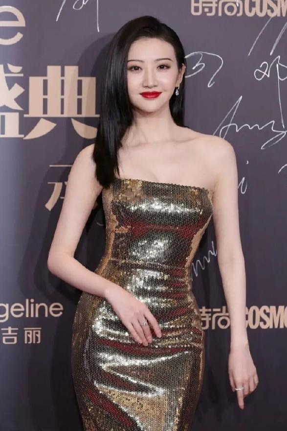 景甜美惊艳亮相,身着一字肩金色亮片抹胸鱼尾长裙,黑色直发搭配红唇