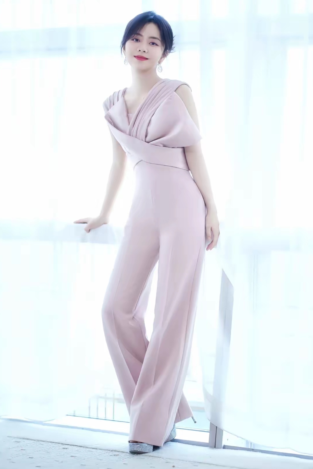 谭松韵身着一袭浅粉色露肩连体裤,独特的褶皱设计与交叉剪裁勾勒出