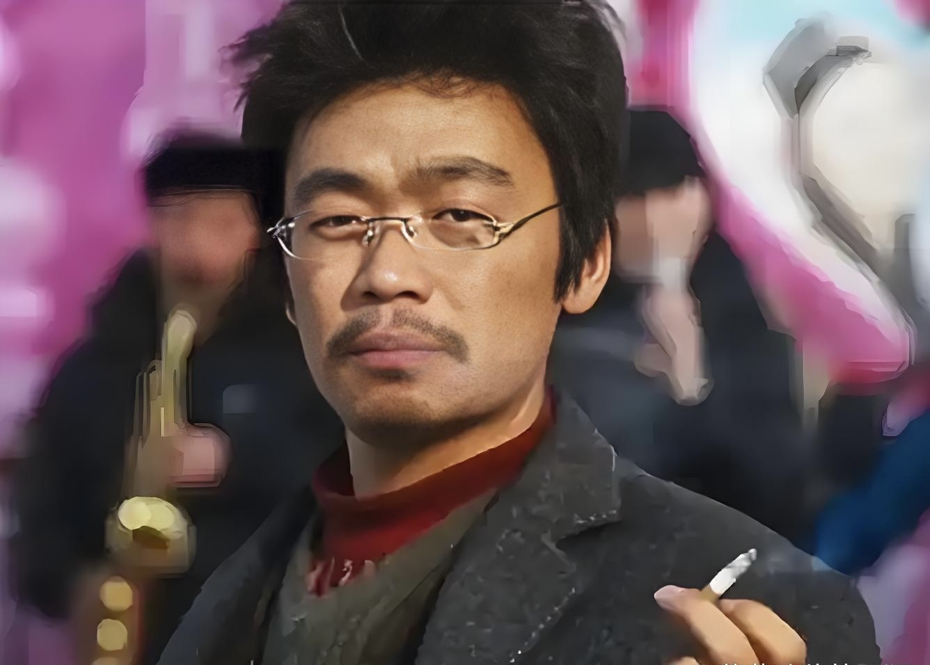 画面里,他身着戏服,脸上带着历经沧桑的神情,夹着烟的手随意垂在身侧