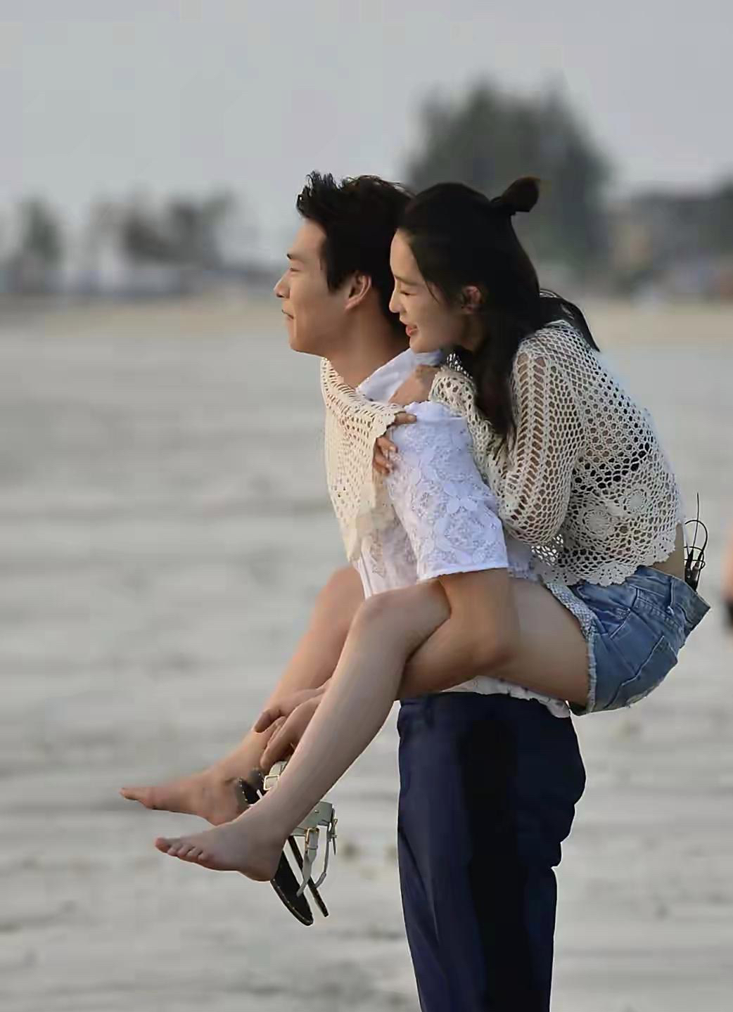 李沁跟她男朋友在海边悠闲地散步,走着走着,李沁还调皮地骑到男朋友