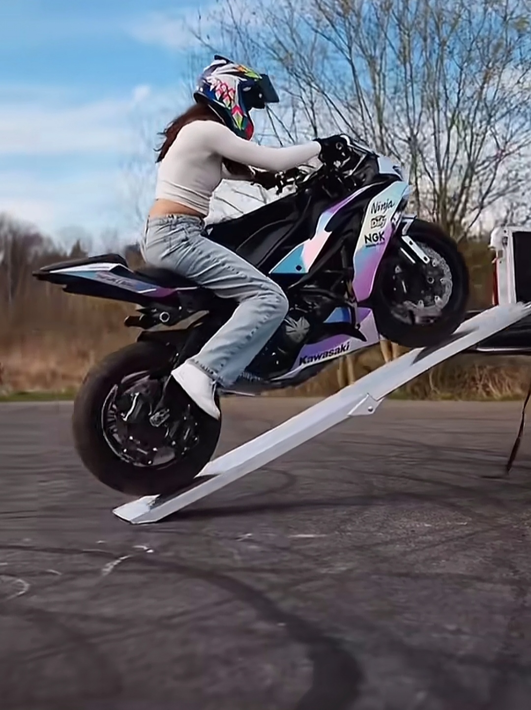 引擎轰鸣划破长空,她身穿白t恤跨上摩托,利落的身影宛如追风者