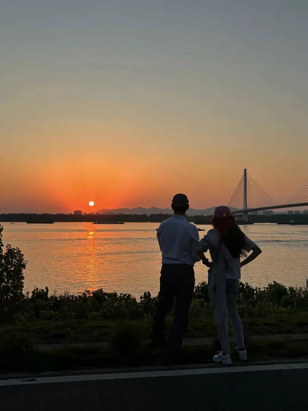 二人静静观赏日落,背影融入余晖,画面如童话般梦幻