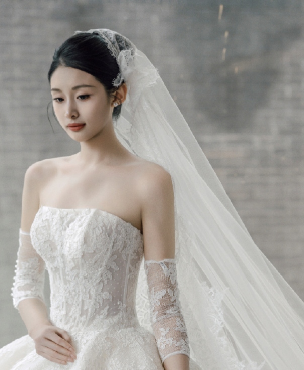 洁白的婚纱勾勒出她纤细的腰肢,精致的妆容映衬着明亮的双眸,脸颊的