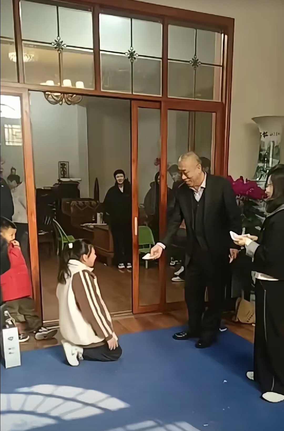 崔培军站在铺着地毯的大厅晚辈们一个接一个从房间走出来扑通一声