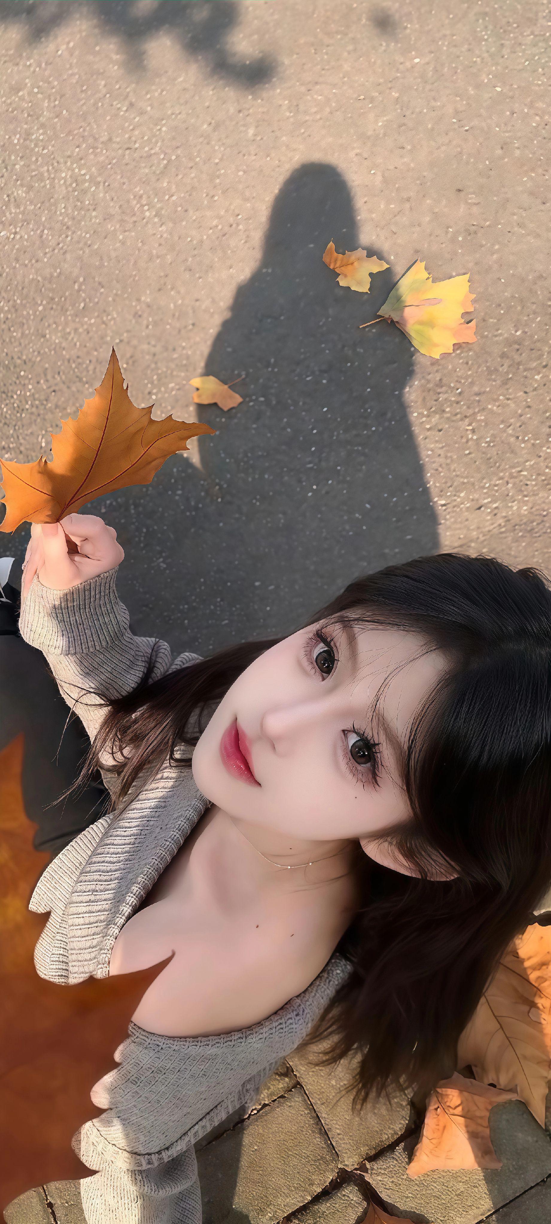 图片中一位穿着灰色毛衣的女子坐在铺有大块石砖的