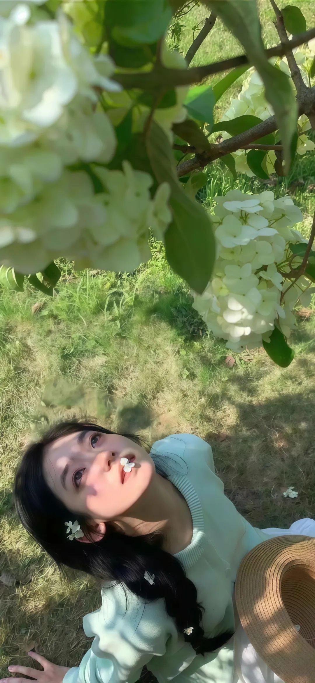 图片展示了一位身穿浅绿色圆领毛衣的女性,坐在草地上,光影斑驳地洒落