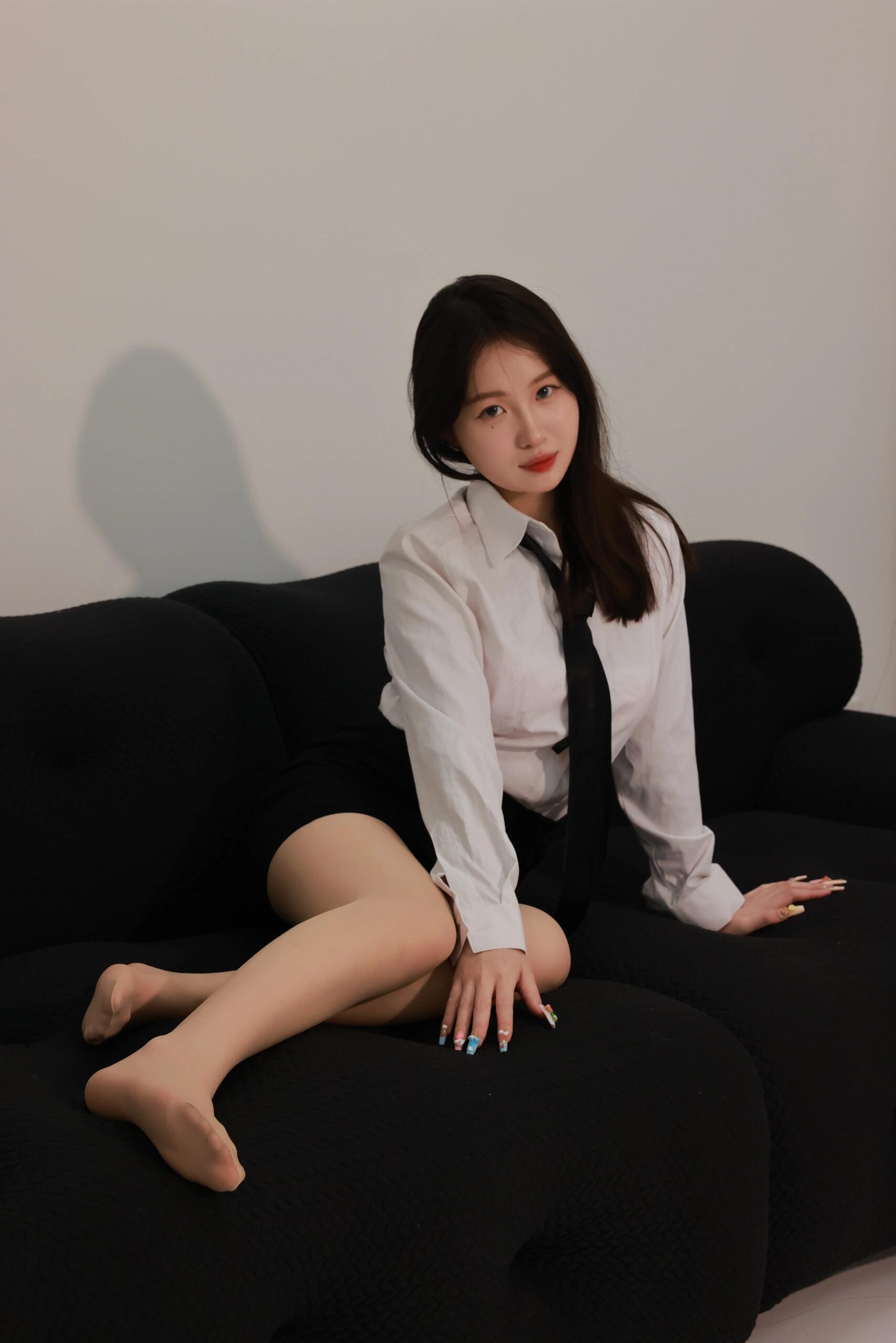 恰到好处的剪裁勾勒出曼妙身姿,肉色丝袜与黑色尖头高跟鞋,增添优雅