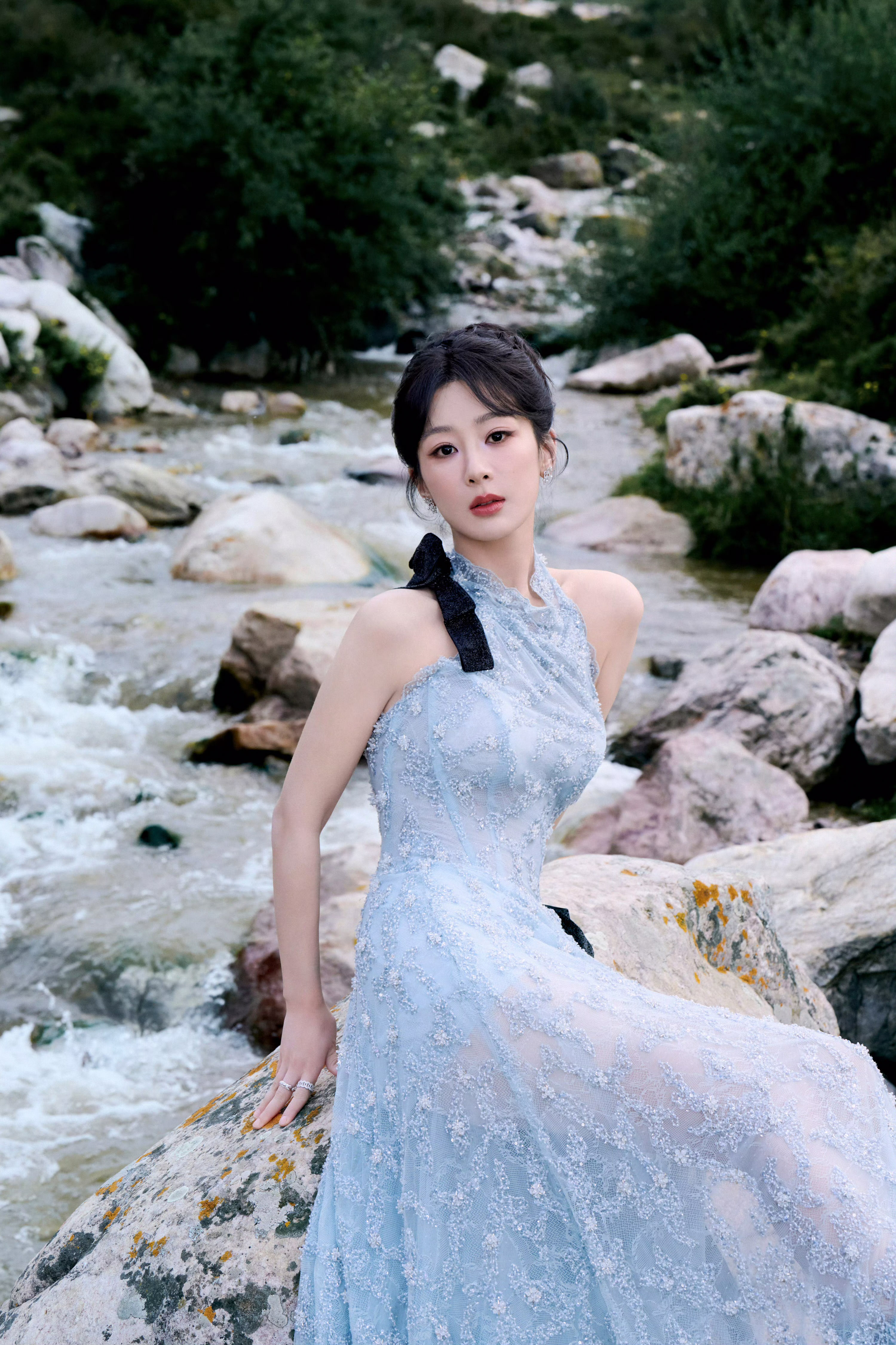 杨紫身着淡蓝色礼裙,在山水间宛如精灵～裙身精致的花纹与黑色蝴蝶结