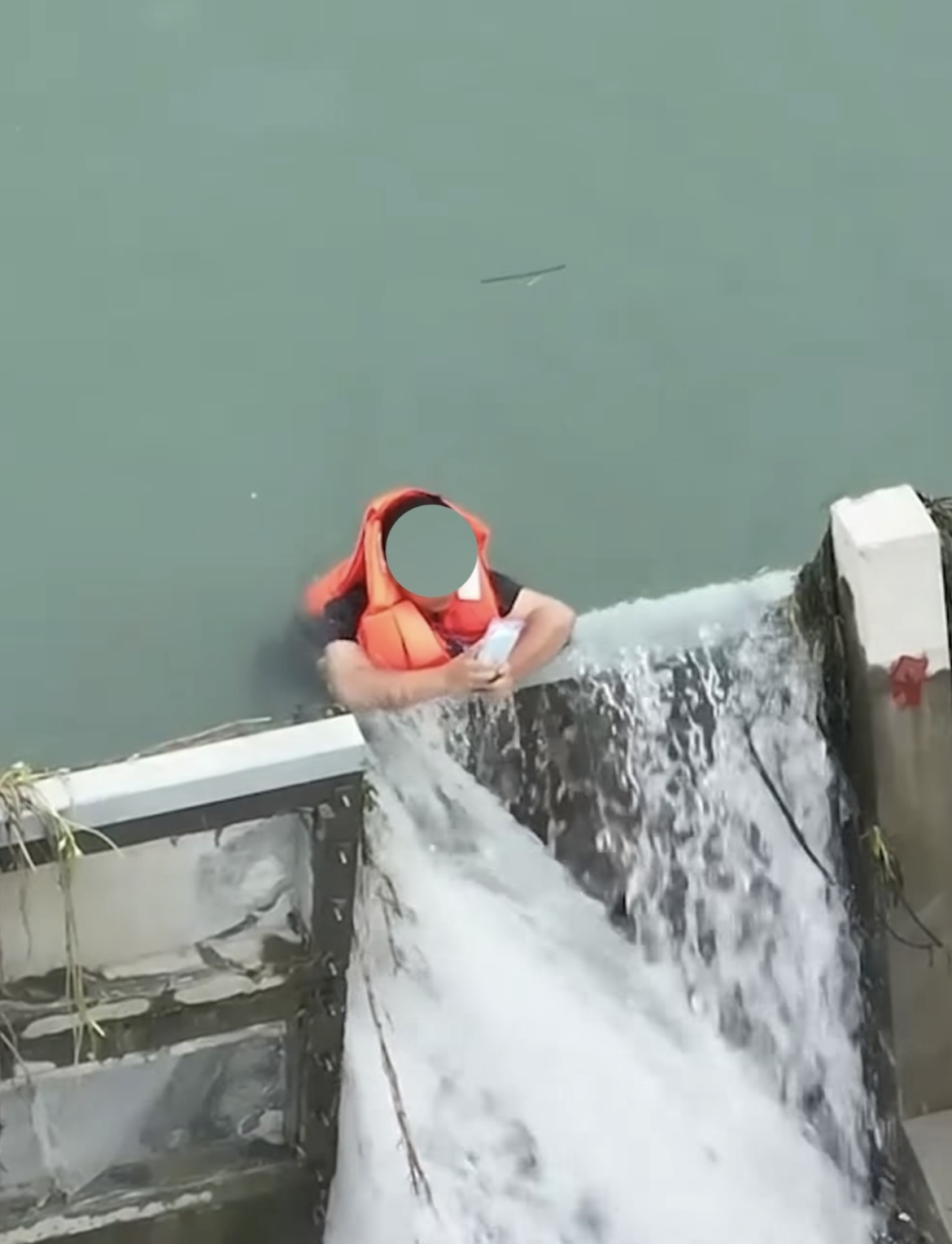 浙江衢州一少年玩皮划艇被冲到了水坝上他死死