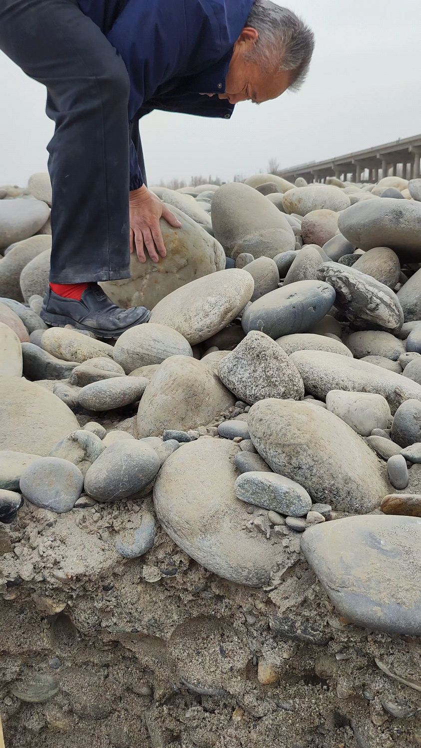 大叔第一天来和田下河捡玉石,总把石头当成宝