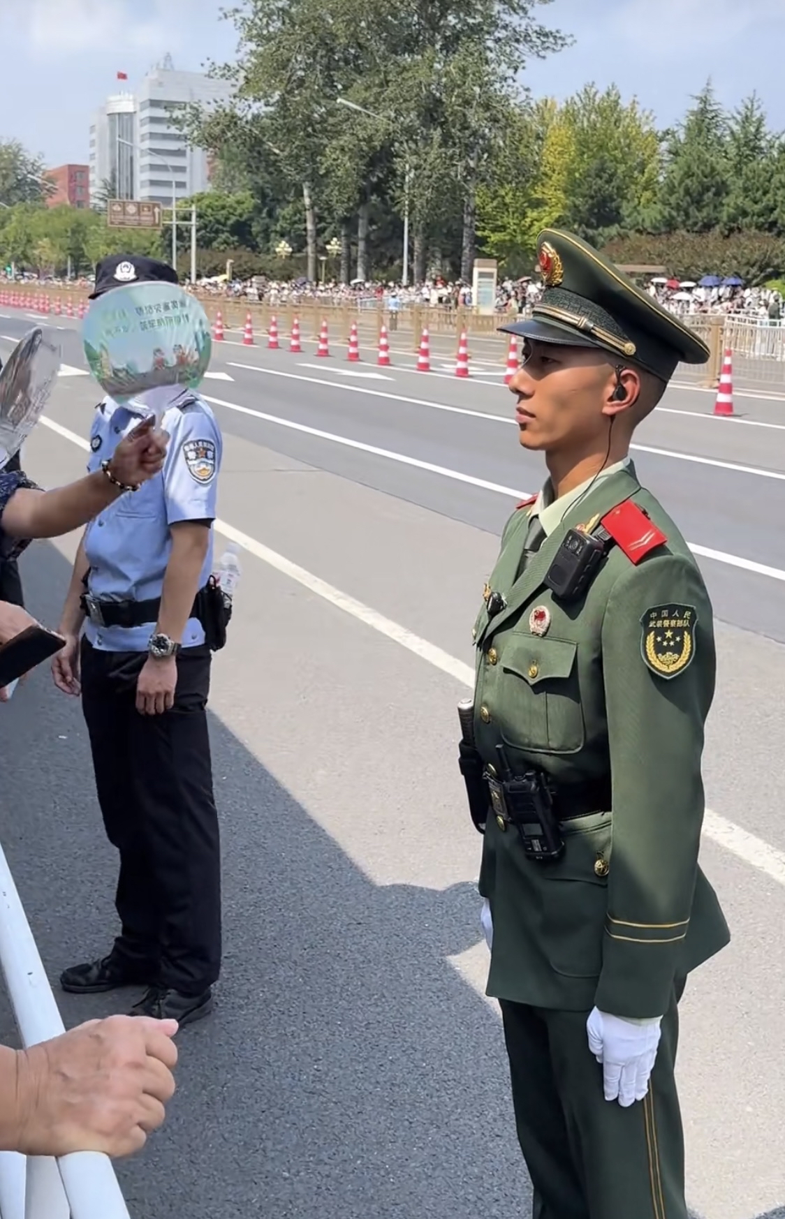 九三阅兵长安街上,观礼的广大市民为执勤的武警战士扇风降温,太贴心了