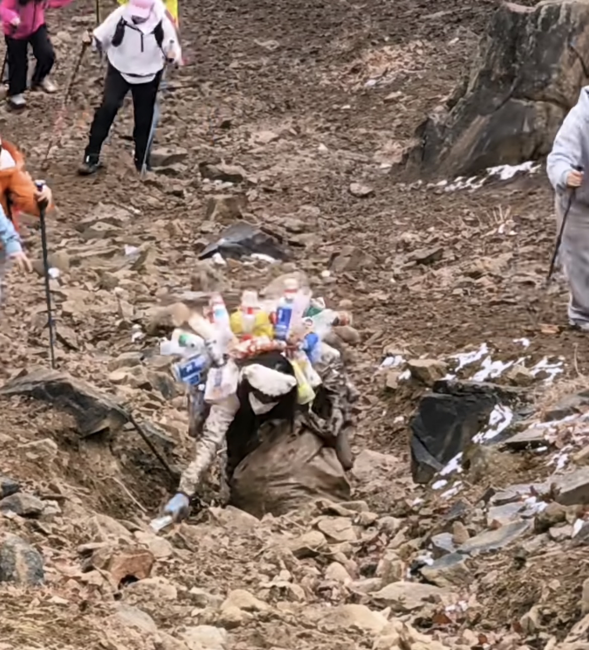 这位姑娘背着比自己还庞大的垃圾包身上挂满了游客丢弃的塑料瓶和