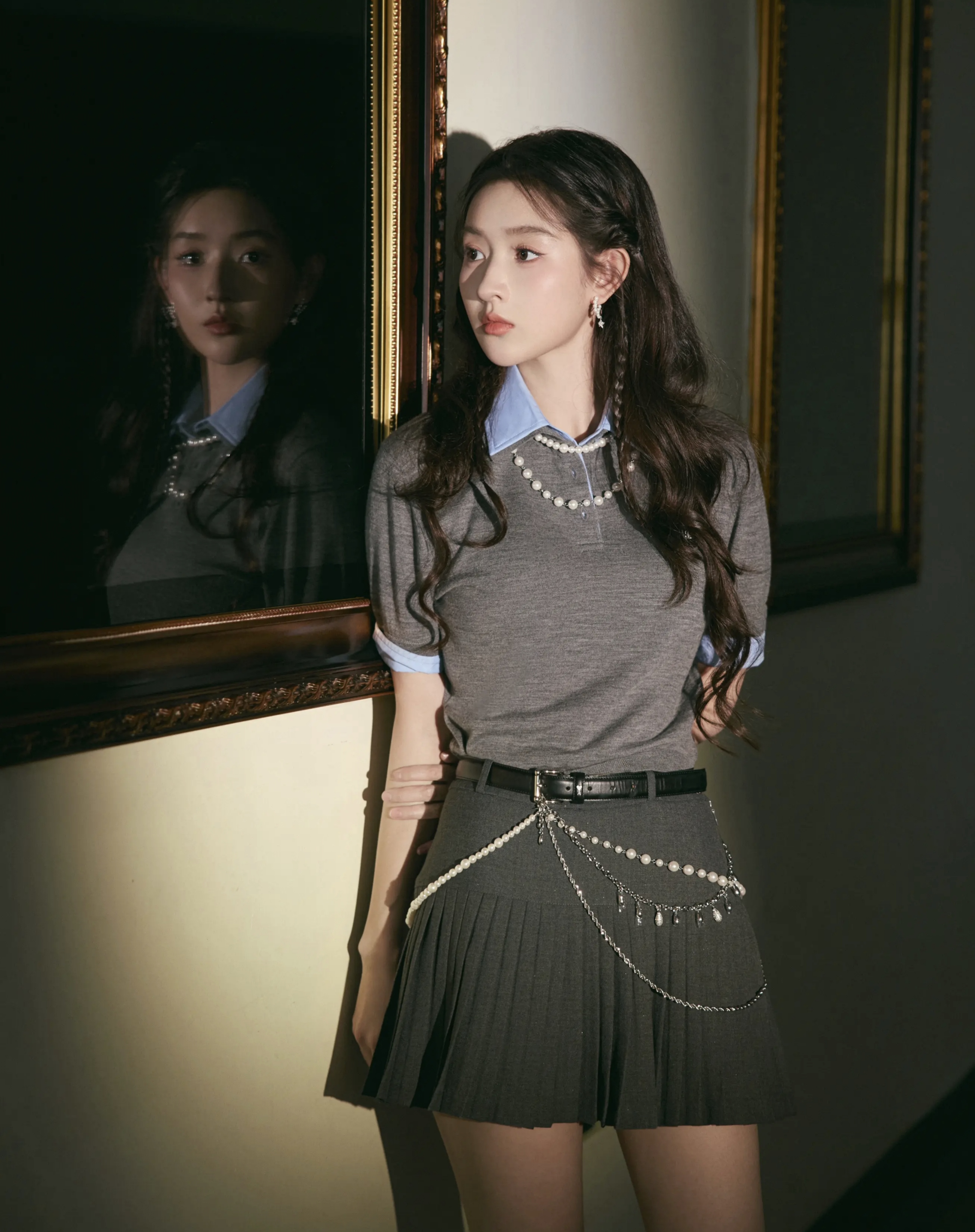 王玉雯身穿灰色毛衣,内搭蓝色衬衫,配黑色百褶裙,尽显优雅气质,散发