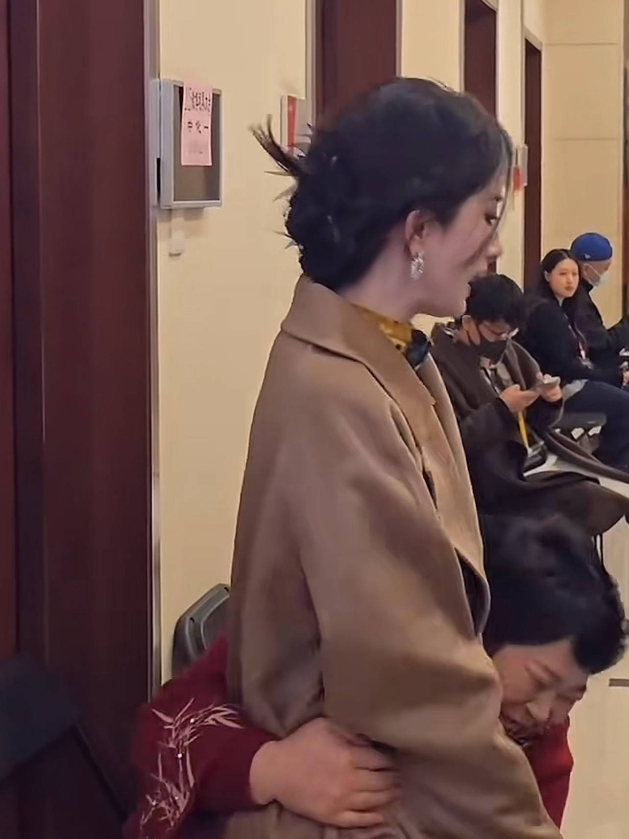 杨幂穿着大地色的大衣妆容发型都很精致房主任看到后一边搂着杨 