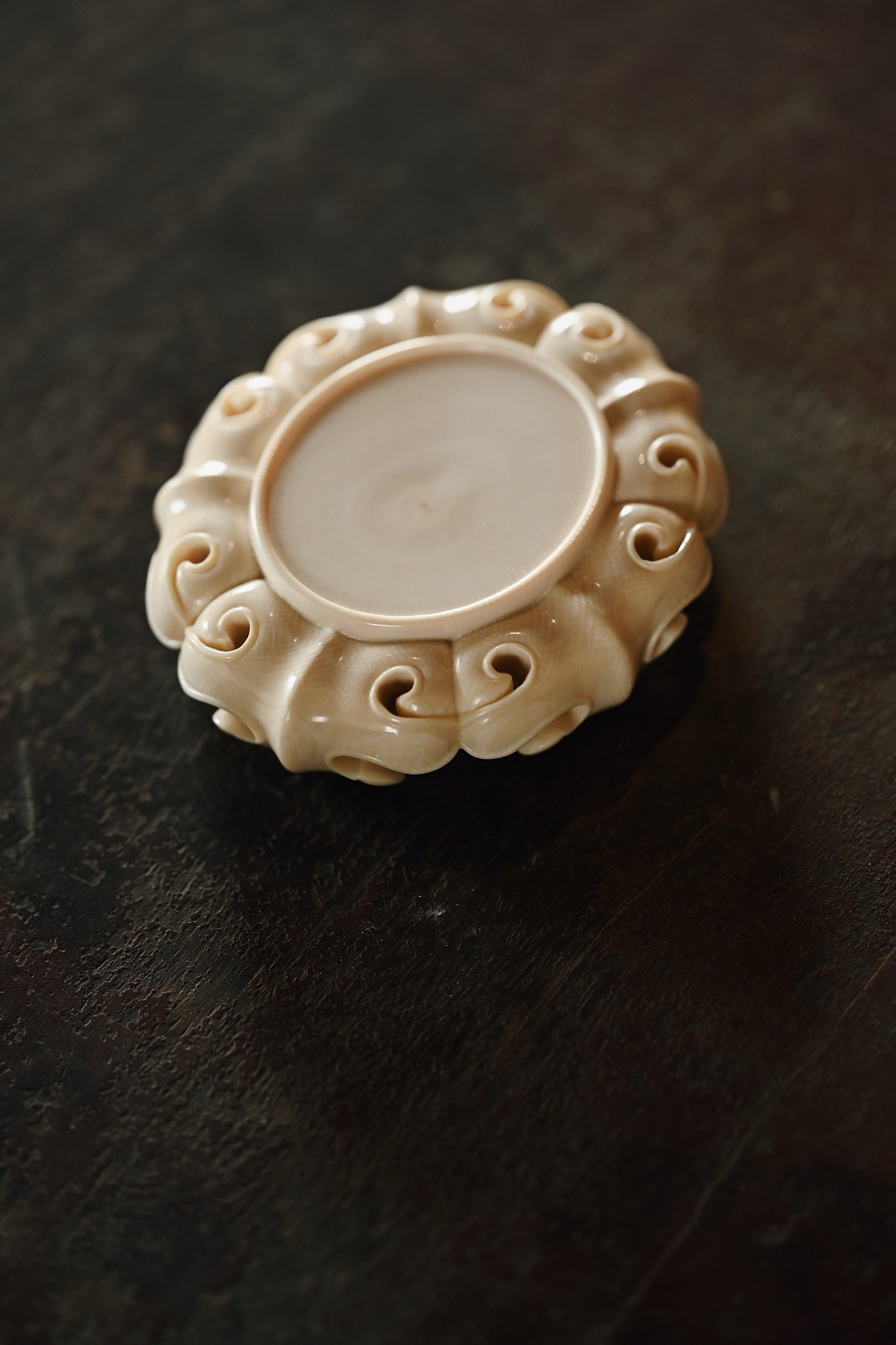 色泽沉润有泽,呈椭圆形,边缘起线,下雕如意纹,造型