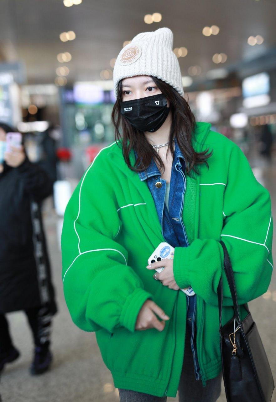 程潇身穿一件鲜艳的绿色棒球服,十分亮眼夺目,里面还搭了一件经典的