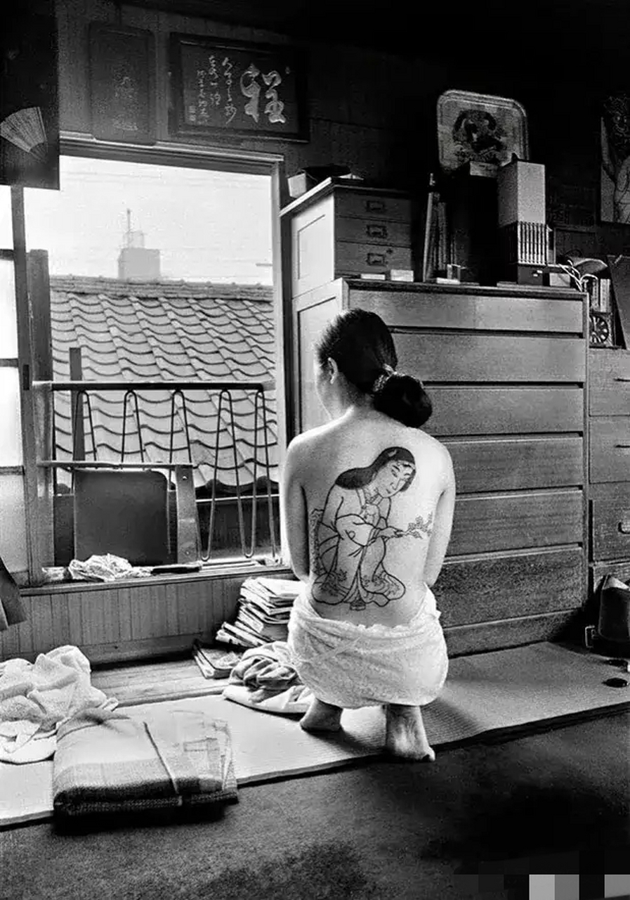 老照片:70年代,日本,著名纹身师崛文正在为一个女孩纹身.