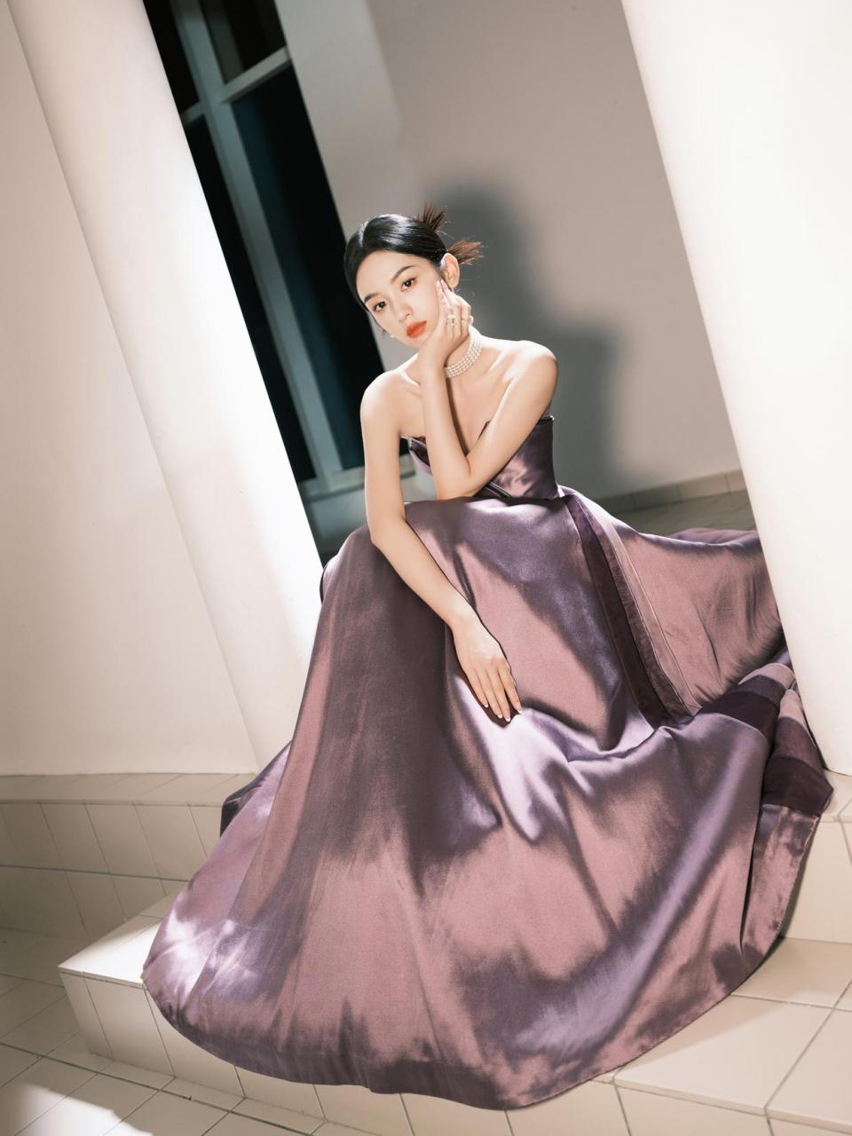 周也穿着一件紫色抹胸裙,优雅迷人,展现了她青春活力和优美的身材.
