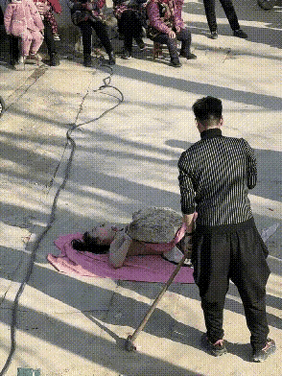 街头表演胸口碎大石,女子被铁锤砸得直叫唤,丈夫下手又准又狠,200块