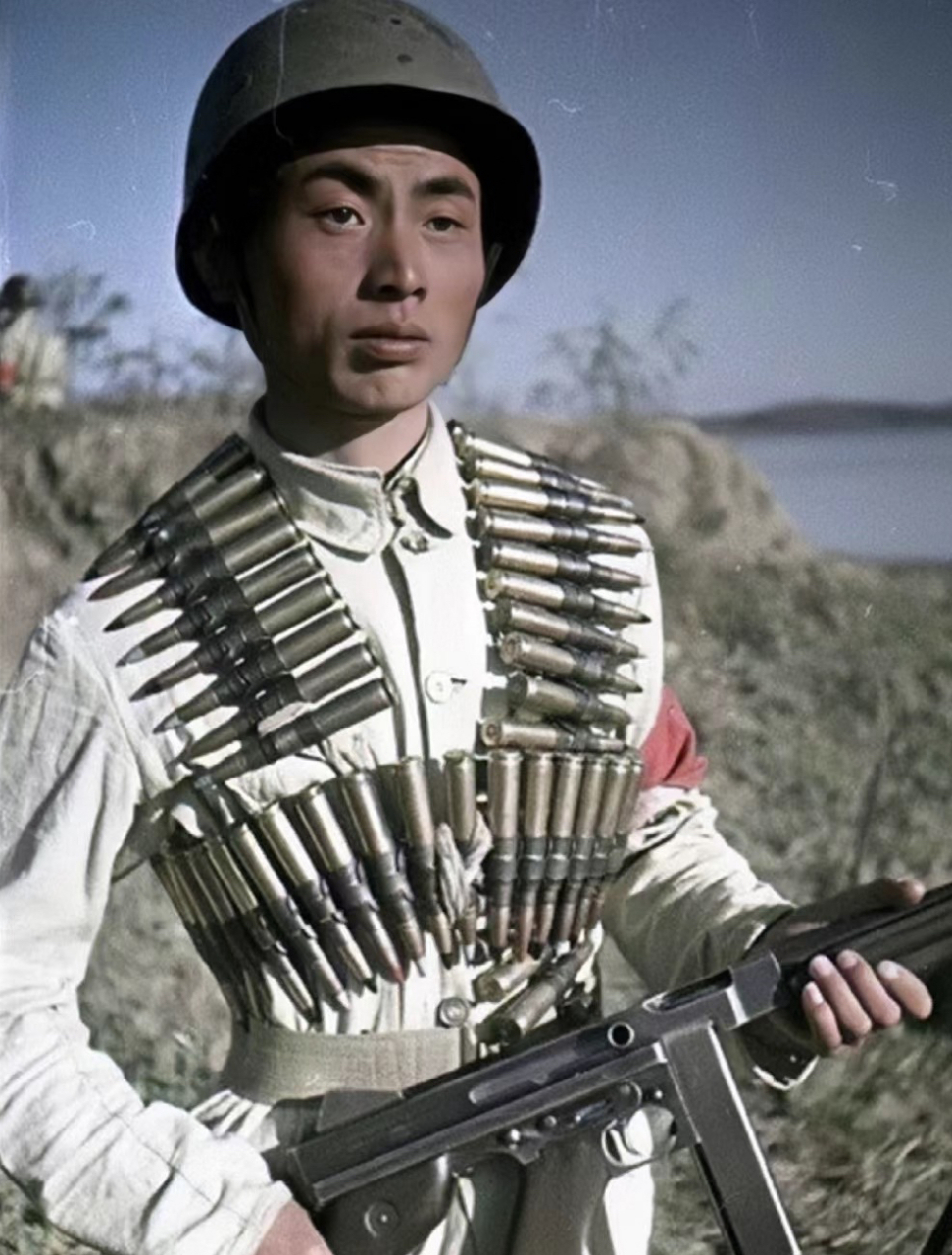 1949年,一名英姿飒爽的解放军士兵手持汤普森冲锋枪,腰缠重型机枪子弹