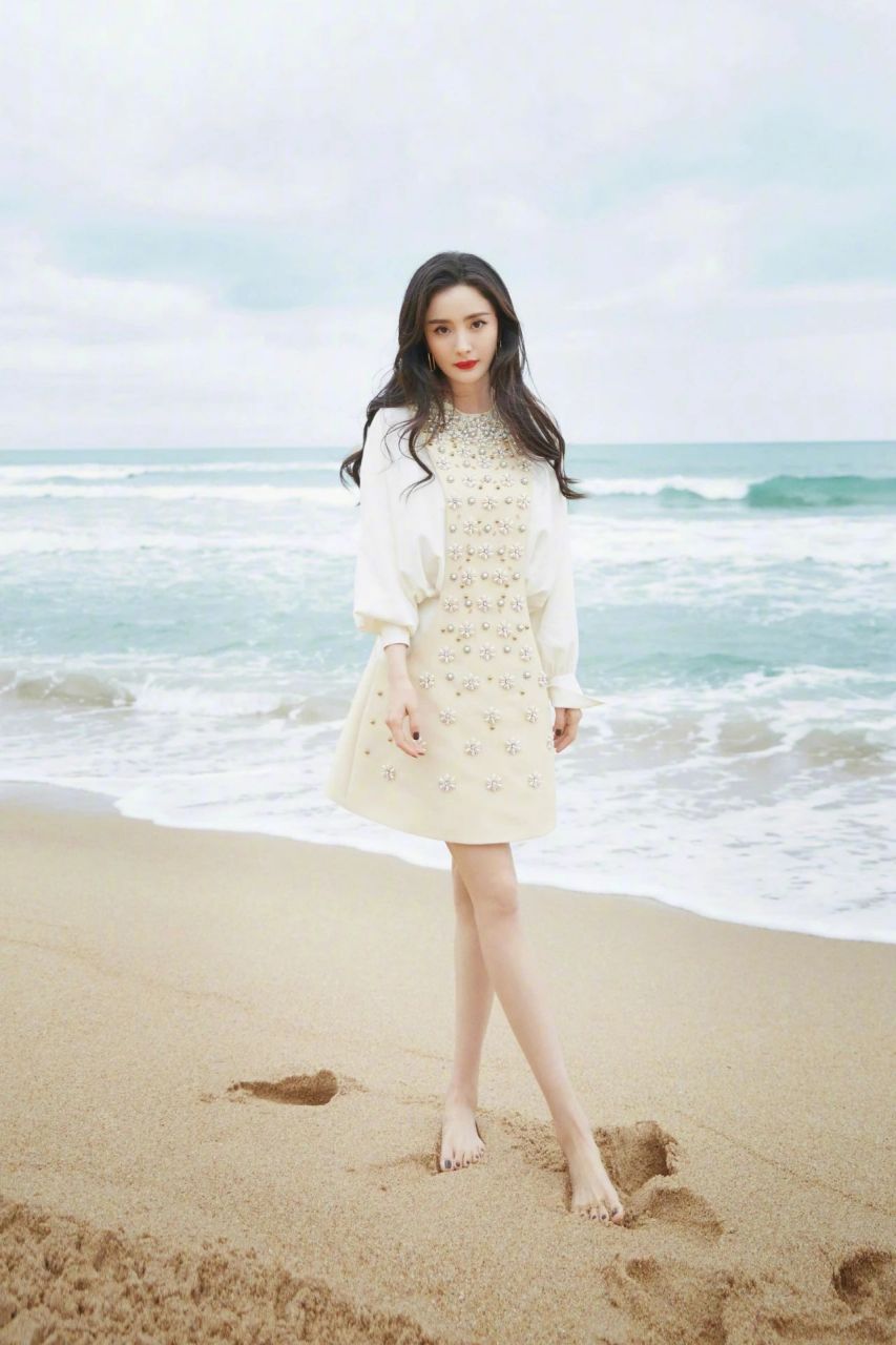 杨幂身着素色a字短裙, 光脚丫在海滩随拍,纤细美腿小清新风格.