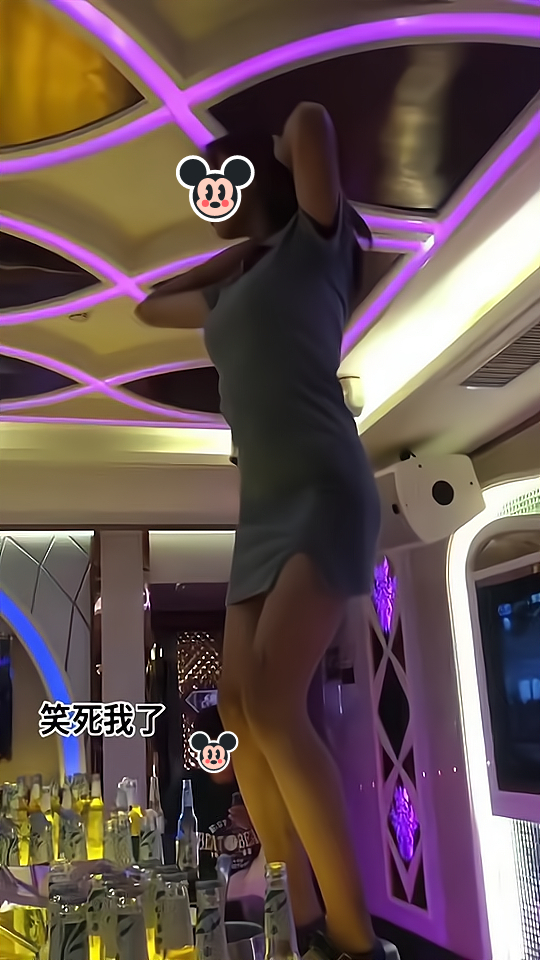 一女子喝醉酒后站在桌子上跳舞,其老公低头看手机,没有搭理她