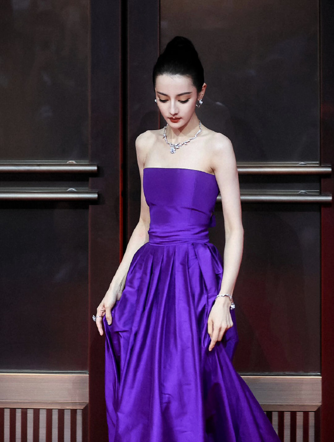 迪丽热巴参加活动,丸子头配紫色抹胸礼服长裙,美艳大气甜美俏皮
