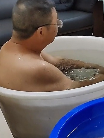 为响应号召节约用水用电,四川一对爷孙泡在水桶里降温!