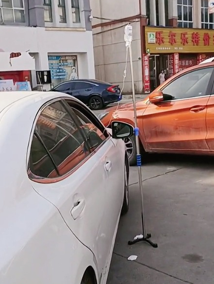 一医院门口,数名车主在车内开窗打吊瓶