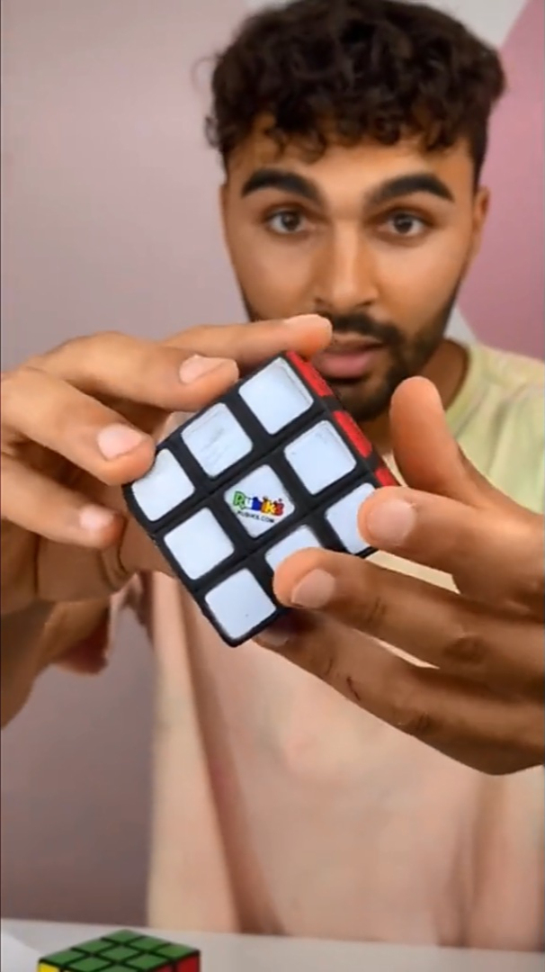 男子手拿一个假的魔方变魔术,屏幕前的观众都迷糊呢吧