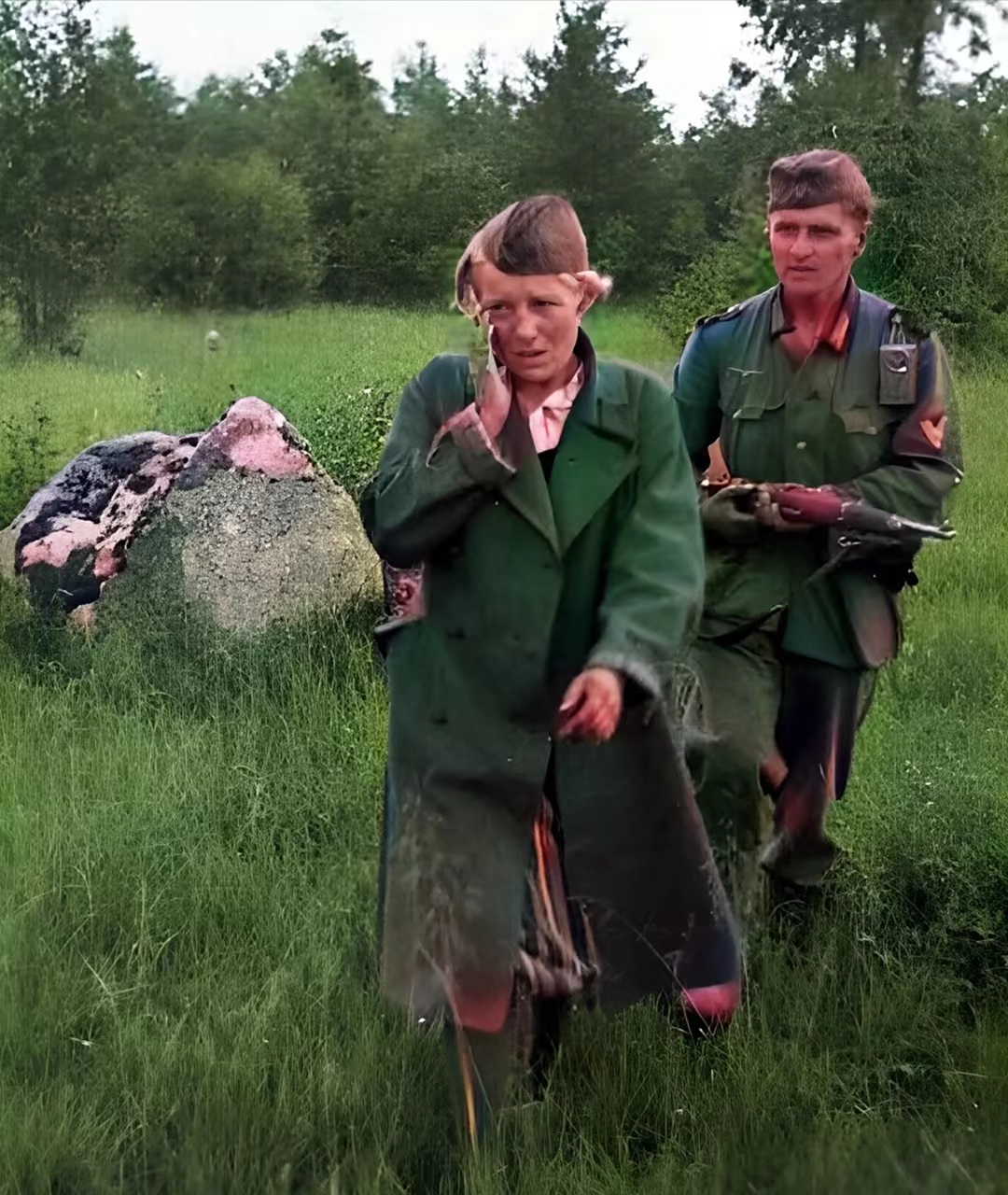 二战时期,一名苏联女兵被俘虏时的场景,此时一名德国士兵双手持枪押着